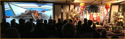 Devotees watching a sacred fire puja on the new 25 foot screen